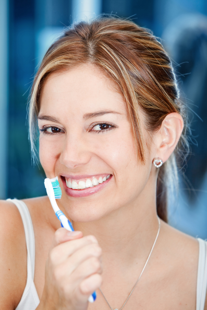Beautiful woman holding a toothbrush in front of her face
